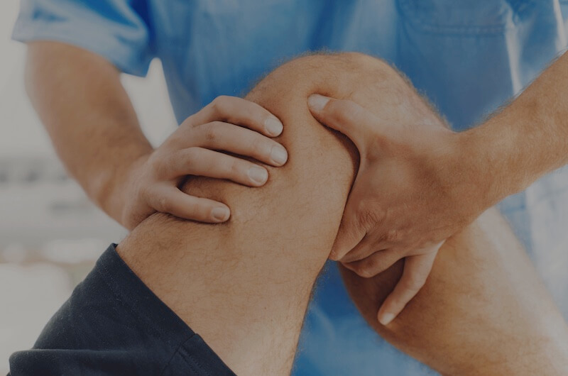 Physiotherapist adjusts patients knee, rehabilitates patient body